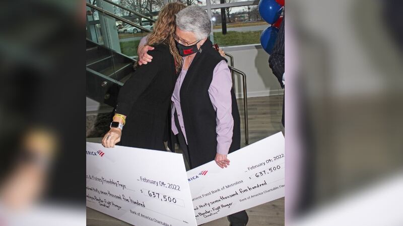 The leaders of the non-profits Second Harvest and Loaves & Fishes hug after Bank of America...